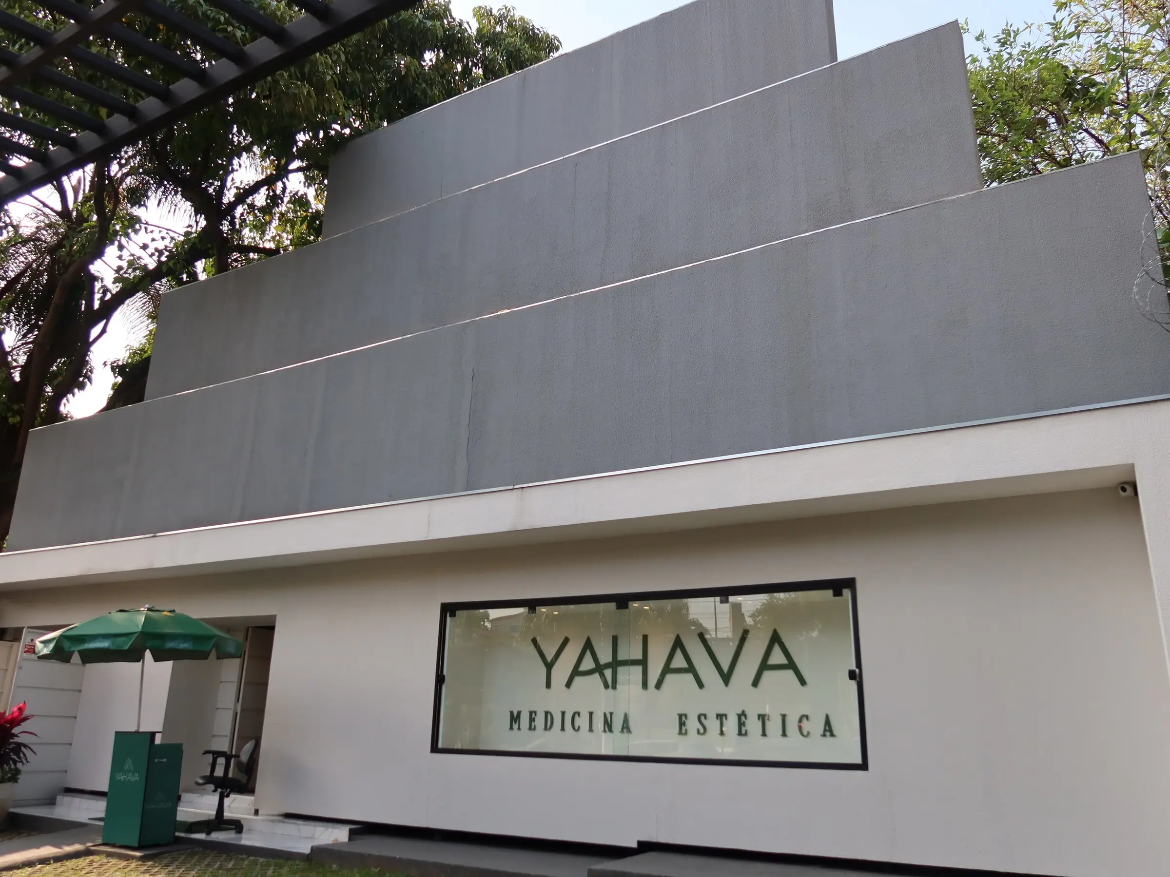 Fachada da Yahava na Rua Alagoas, 1066, com o letreiro Yahava Medicina Estética, o jardim e o guarda-sol verde