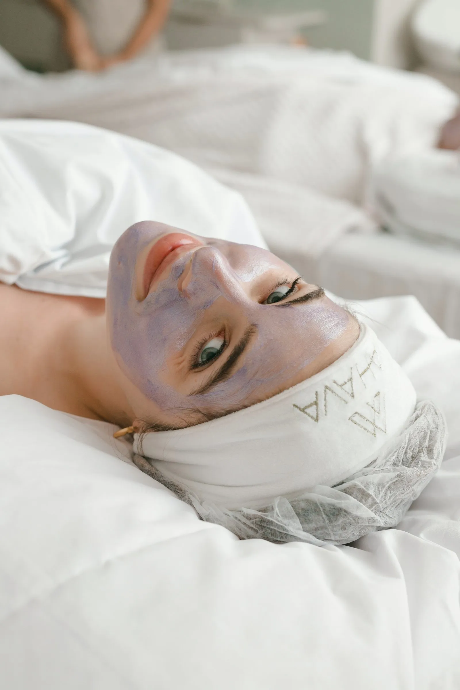 Cliente deitada na maca, com máscara facial e os cabelos presos pela faixa da Yahava