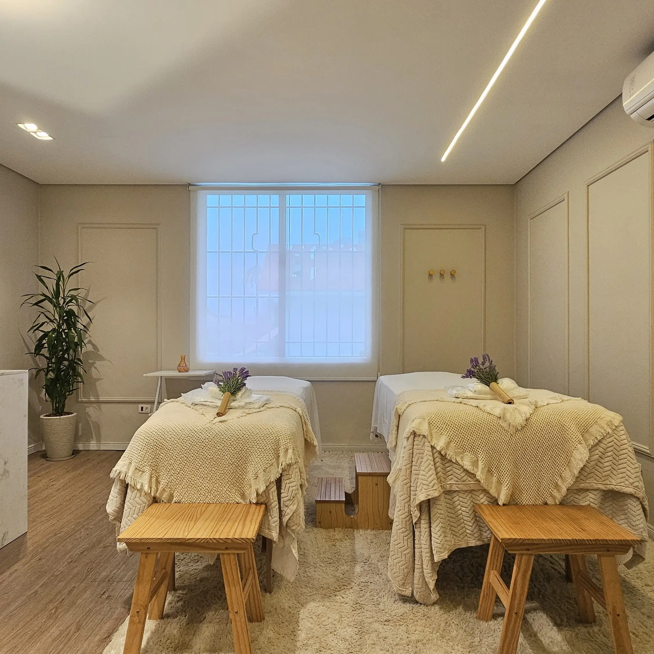Sala de massagem da Casa Yahava com duas macas, mantas de tricô, lavanda e luz de janela